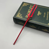 Red zinc alloy anime-style weapon replica on Hamlet book, BlacksmithSONG collectible