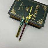 Anime-style zinc alloy sword replica with gold and blue details on a Hamlet book