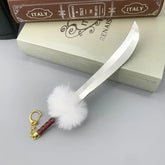 1:6 scale anime-style zinc alloy sword keychain with fluffy pompom, displayed on books