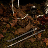 Anime-style zinc alloy sword with detailed engravings, black scabbard, pearl necklace on moss and autumn leaves