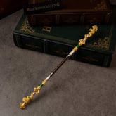 Loongwreathe Staff replica (22cm die-cast zinc alloy cudgel) — gold-toned dragon ends on a dark shaft, resting on old hardcovers, by BlacksmithSONG.