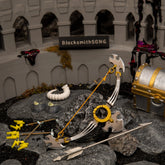 The complete 15cm metal Savage Lynel Bow prop and arrow resting on dark rocks amidst a Coliseum ruins diorama, featuring a Malice-covered chest and a white Lynel horn.