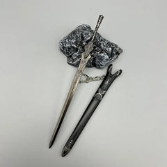 1:6 scale anime-style zinc alloy sword replica with black sheath, displayed on stone, collectible.