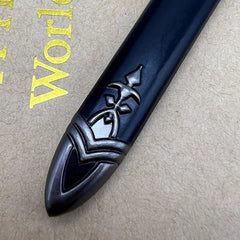 Close-up of zinc alloy anime-style sword tip with engraved design, on textured backdrop