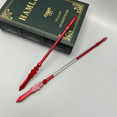 Red zinc alloy anime-style weapon replica spears beside a green Hamlet book on a gray surface.