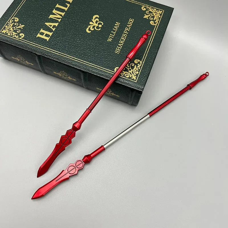 Red zinc alloy anime-style weapon replica spears beside a green Hamlet book on a gray surface.