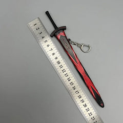 Anime-style zinc alloy sword keychain collectible with red and black details beside a ruler