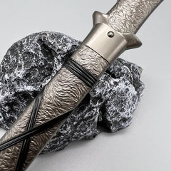 1:6 scale anime-style zinc alloy sword replica with textured handle on stone, BlacksmithSONG collectible.