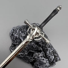 Anime-style zinc alloy sword replica with ornate hilt on stone display, BlacksmithSONG collectible.
