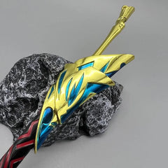 Anime-style 1:6 zinc alloy sword replica with gold and blue details on a stone display