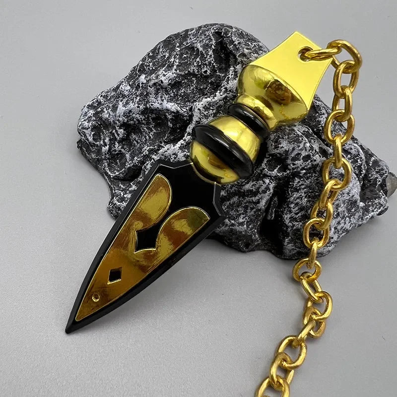 Anime-style zinc alloy weapon replica with gold and black details on a stone, gold chain attached.