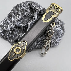 Anime-style zinc alloy weapon replica keychain with gold accents on stone, BlacksmithSONG collectible