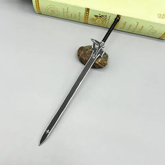 Anime-style 1:6 zinc alloy sword replica displayed on a table near a book for cosplay or display.