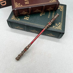 Anime-style red zinc alloy replica wand on vintage books, collectible cosplay accessory