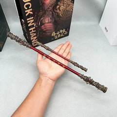 Hand holding a 1:6 anime-style zinc alloy staff replica with ornate gold details, collectible display.