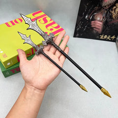 Hand holding two anime-style zinc alloy weapon replicas for cosplay and display