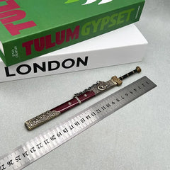 1:6 anime-style zinc alloy sword replica with ornate red sheath beside ruler and books.