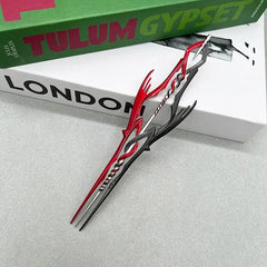 Anime-style red and silver zinc alloy weapon replica on books, collectible display by BlacksmithSONG