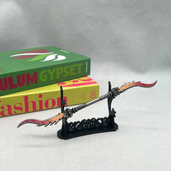 Anime-style zinc alloy weapon replica on stand, displayed near colorful books, BlacksmithSONG collectible.