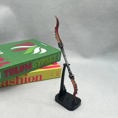 Anime-style zinc alloy spear replica collectible on stand, with books in background