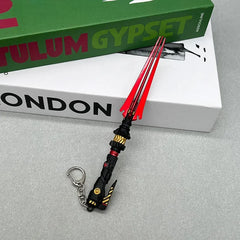 Anime-style zinc alloy trident keychain collectible on books, BlacksmithSONG cosplay replica.