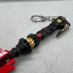 Anime-style 1:6 zinc alloy weapon replica keychain with red, black, and gold accents on gray surface.