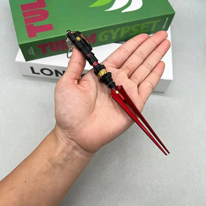 Hand holding a 1:6 anime-style zinc alloy weapon replica keychain with red blades