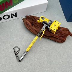 Anime-style yellow zinc alloy weapon replica keychain on wood, BlacksmithSONG collectible.