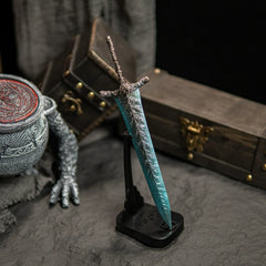 Transform your gaming desk into Ranni’s Rise with this Dark Moon Greatsword metal replica.  Displayed on a custom stand, this Elden Ring sword features stunning frost-blue details and antique weathering. The perfect gaming room accessory or gift for Soulsborne fans.-Vertical display stand