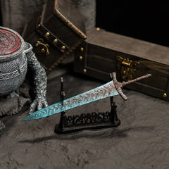 Transform your gaming desk into Ranni’s Rise with this Dark Moon Greatsword metal replica.  Displayed on a custom stand, this Elden Ring sword features stunning frost-blue details and antique weathering. The perfect gaming room accessory or gift for Soulsborne fans.-large display stand