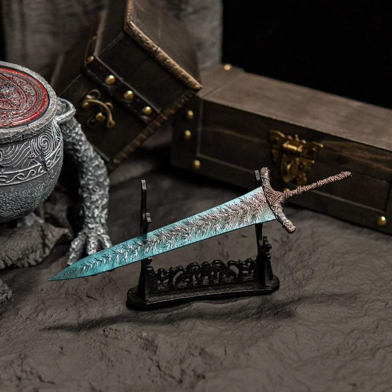 Transform your gaming desk into Ranni’s Rise with this Dark Moon Greatsword metal replica.  Displayed on a custom stand, this Elden Ring sword features stunning frost-blue details and antique weathering. The perfect gaming room accessory or gift for Soulsborne fans.-large display stand