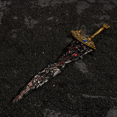 Top-down view of Maliketh's Black Blade lying on black sand.