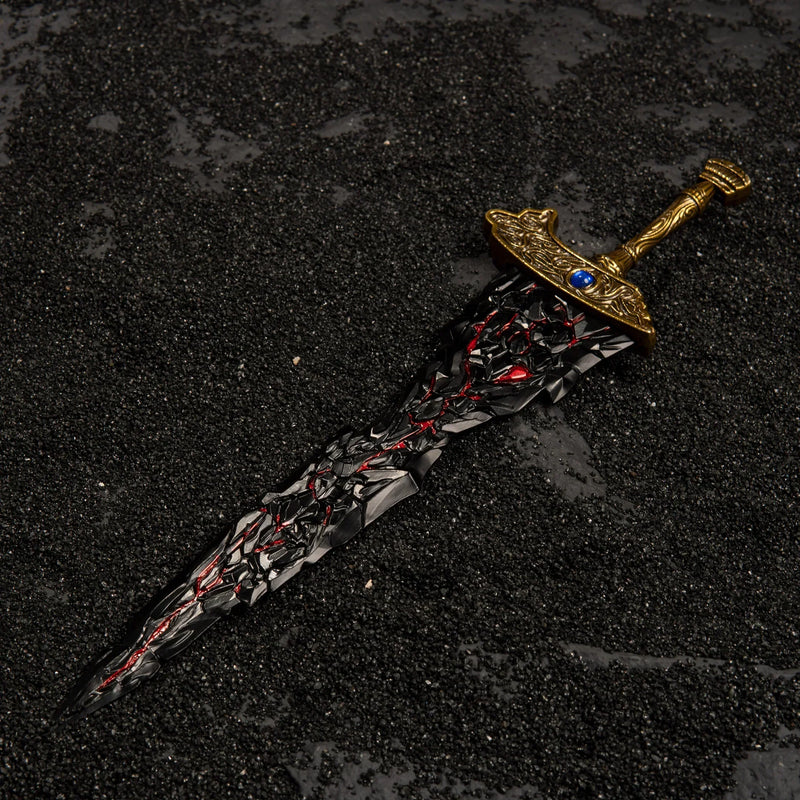 Top-down view of Maliketh's Black Blade lying on black sand.