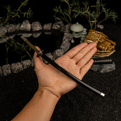 See the Moonveil Katana in its sheath!  This handheld shot shows the realistic 22cm scale of our metal replica. Featuring a glossy black scabbard and detailed hilt, it's a high-quality collectible for Elden Ring fans. Perfect for display or as a small cosplay prop.