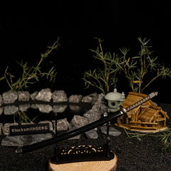 Add a touch of magic to your gaming setup.  This Moonveil Katana metal replica is displayed on a sleek black stand, perfect for a Zen-inspired desk theme. Crafted from zinc alloy, this Elden Ring weapon brings the calm and deadly aesthetic of the Transient Moonlight to your room. - Large display rack
