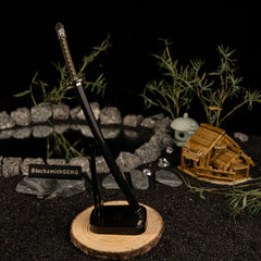 Add a touch of magic to your gaming setup.  This Moonveil Katana metal replica is displayed on a sleek black stand, perfect for a Zen-inspired desk theme. Crafted from zinc alloy, this Elden Ring weapon brings the calm and deadly aesthetic of the Transient Moonlight to your room. - Vertical display rack