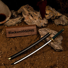 Reach is everything.  This Nagakiba metal replica captures the insane length of the "Washing Pole" katana from Elden Ring. Displayed on a blood-soaked battlefield base, it's the ultimate tribute to Bloody Finger Hunter Yura. A standout Elden Ring desk accessory for Dexterity builds.