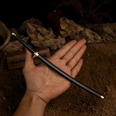 Hold the Washing Pole!  This handheld shot shows the 22cm scale of our Nagakiba replica. Even in miniature form, this metal katana feels substantial. Features a detailed green wrapped handle and a matching black scabbard. The perfect collectible for your shelf or backpack.