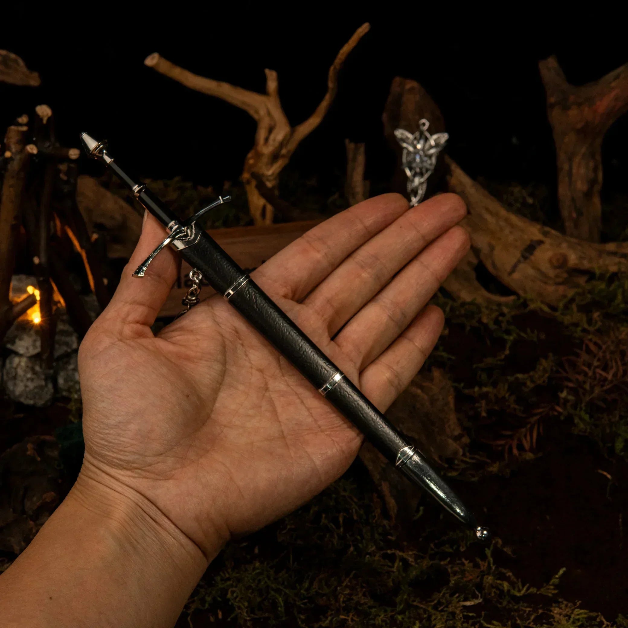 Hand holding 1:6 anime-style zinc alloy sword replica collectible against rustic backdrop