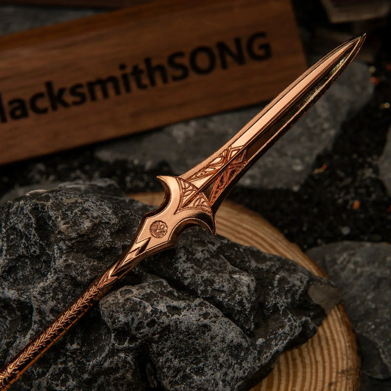 Gungnir replica — spearhead and wing-flared crossguard detail, close-up.