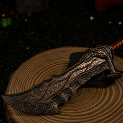 Blades of Chaos replica — clawed guard and wrapped grip in close-up on a wooden base.