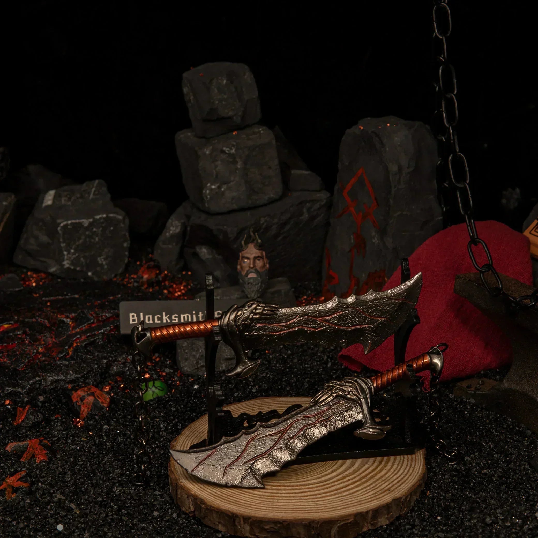 Angled view of God of War metal replicas displayed on a horizontal stand.