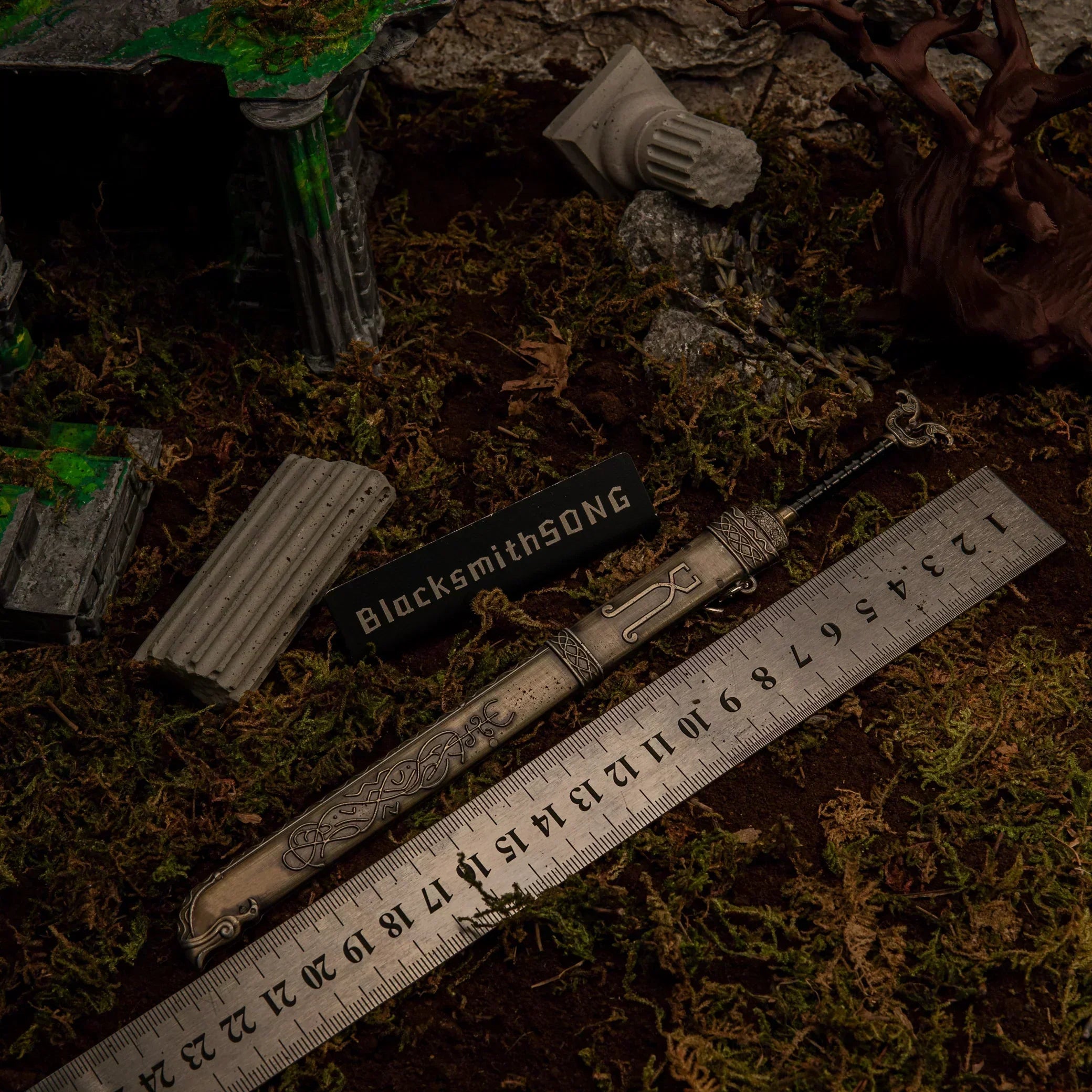 A metal Thrungva sword replica laid next to a ruler showing a length of 22 centimeters.