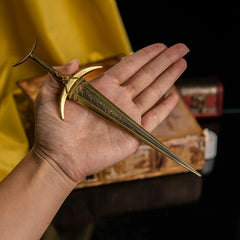 A hand holding the Golden Order Greatsword miniature to show scale.
