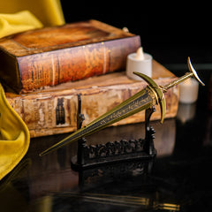 Golden Order Greatsword metal sword displayed on a large horizontal stand with vintage books in the background.
