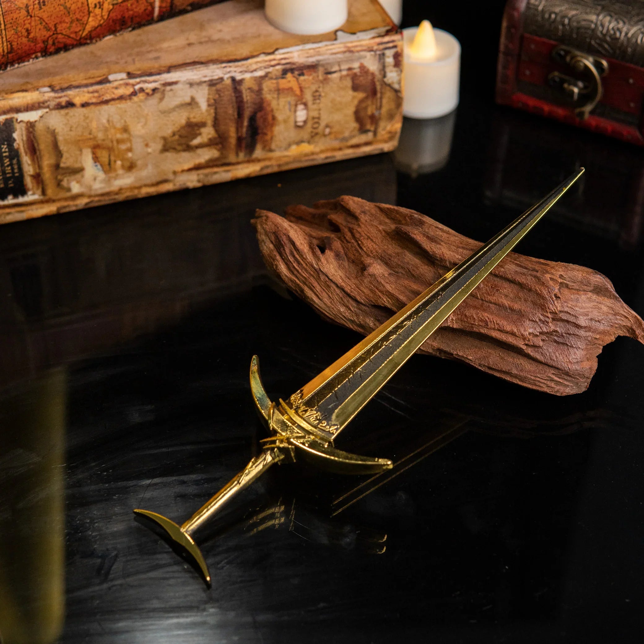 Golden Order Greatsword metal replica displayed on a dark surface with yellow silk fabric in the background.