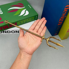 Hand holding 1:6 scale anime-style gold trident zinc alloy weapon replica collectible