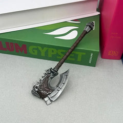 1:6 anime-style zinc alloy axe replica with skull detail, displayed on a tabletop by books