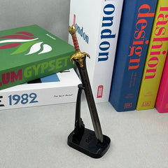 Anime-style zinc alloy sword replica on stand, displayed on desk with colorful books