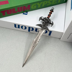 Anime-style zinc alloy sword replica with intricate hilt, displayed on books, BlacksmithSONG collectible.